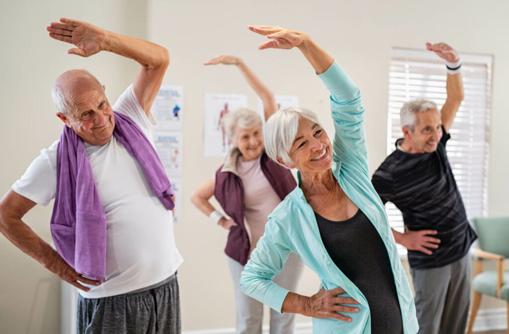 A group of seniors exercising together in a senior living community.
