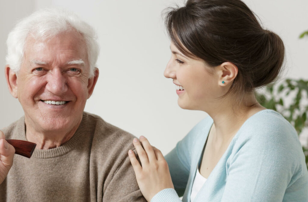 a young woman sitting beside her elderly father, discussing assisted living