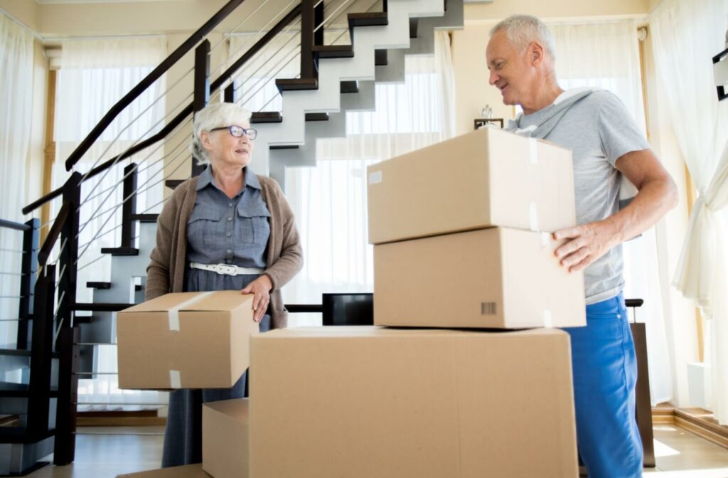 An older adult couple stacking boxes to prepare for moving into an independent living home.